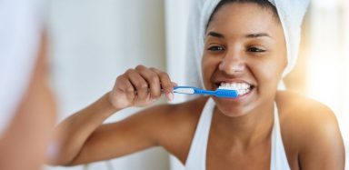 a woman brushing her teeth with whitening toothpaste