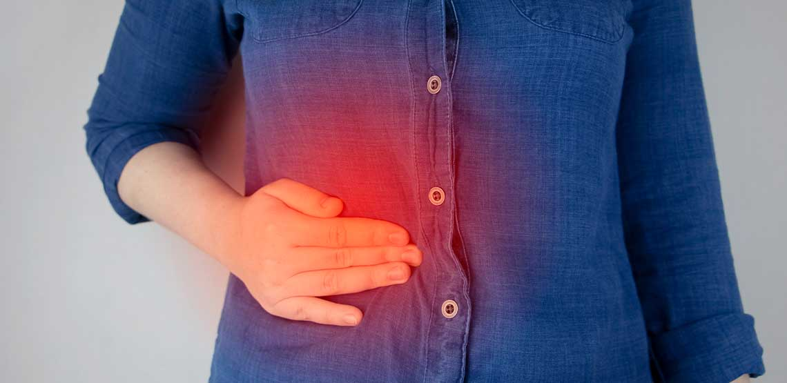 A person holding their upper abdomen with an orb of red outlining where the pain is.