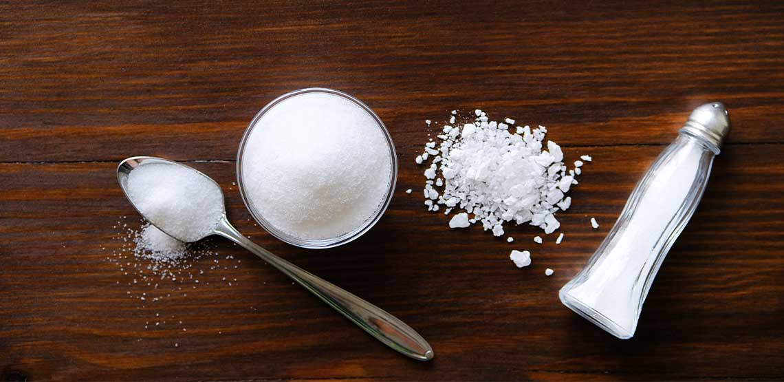 Salt on a dark brown, wooden table.