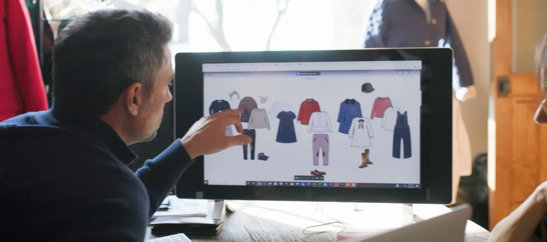 A man looking at a computer screen showing their products