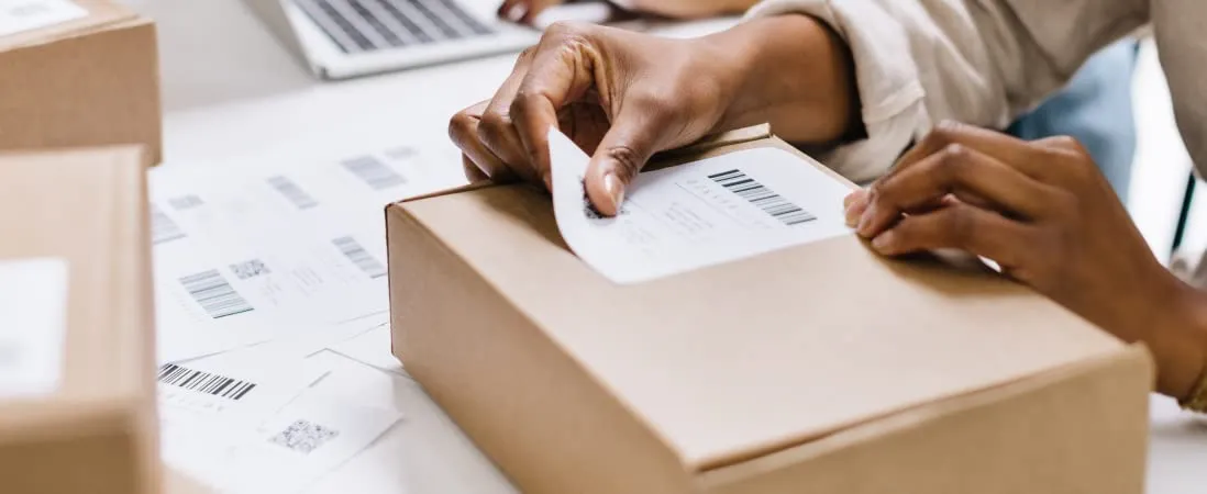 Someone placing a shipping label on a box