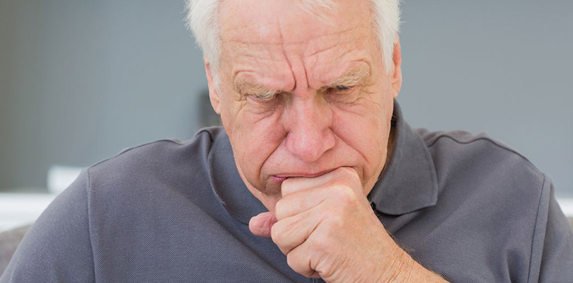 A man is coughing, a known symptom of mesothelioma