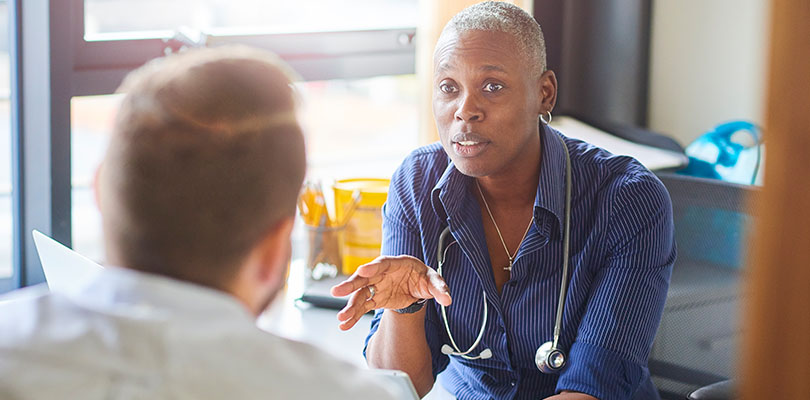 A female physician is consulting a male patient