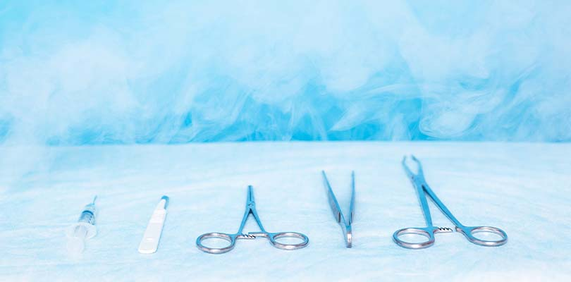 Surgical instruments against a blue background.