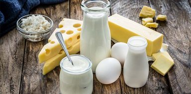 Milk and cheese on a wooden table.