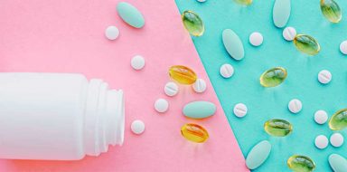 A white pill bottle with pills spilling out of it against a light pink and blue background.