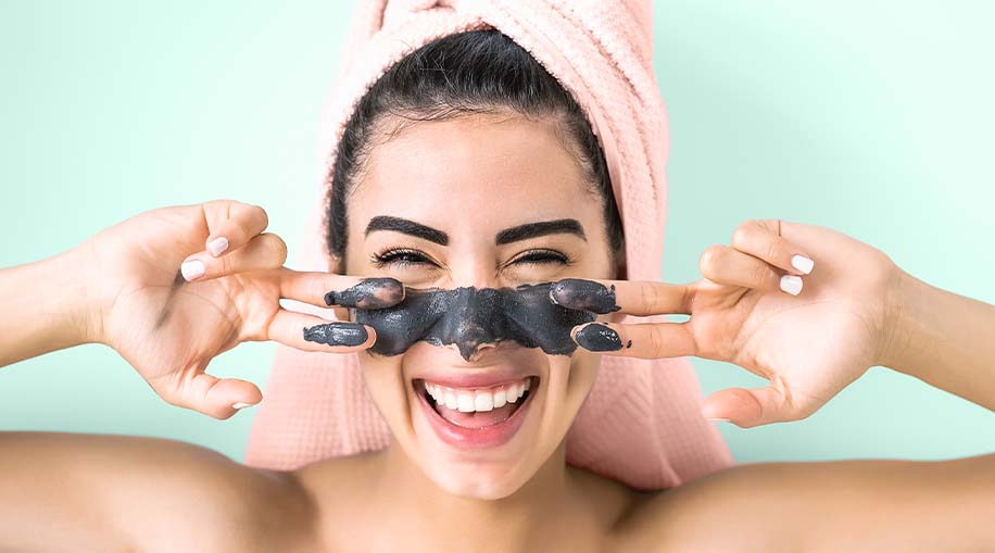 A woman wearing a charcoal facial mask.