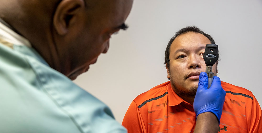 A NIDA clinician performs an eye exam